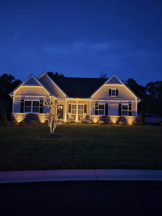 House exterior highlighted with accent lighting at night