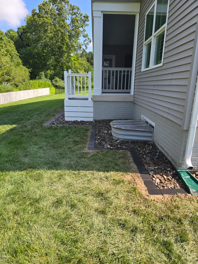 French drain trench routed past an AC condenser unit