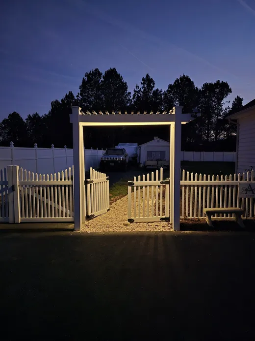 Lit gate and pergola entrance at dusk