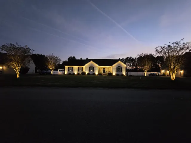 Landscape lighting installation on a ranch home at dusk