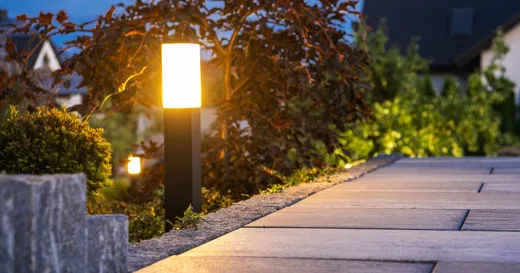 Pathway light fixture illuminated at dusk