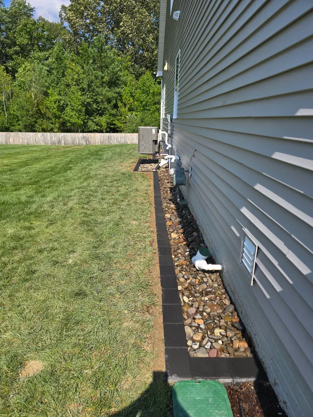 Deck and paver walkway alongside a French drain trench