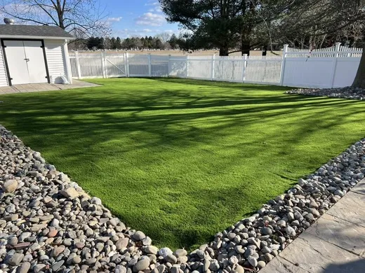 Synthetic putting green turf installed in a fenced backyard